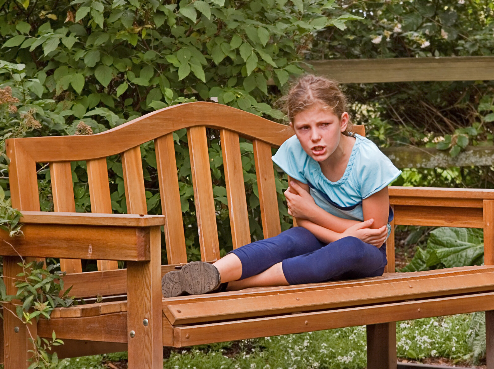 Girl on a bench upset. Photo is part of an article on understanding what it means to be on the spectrum.