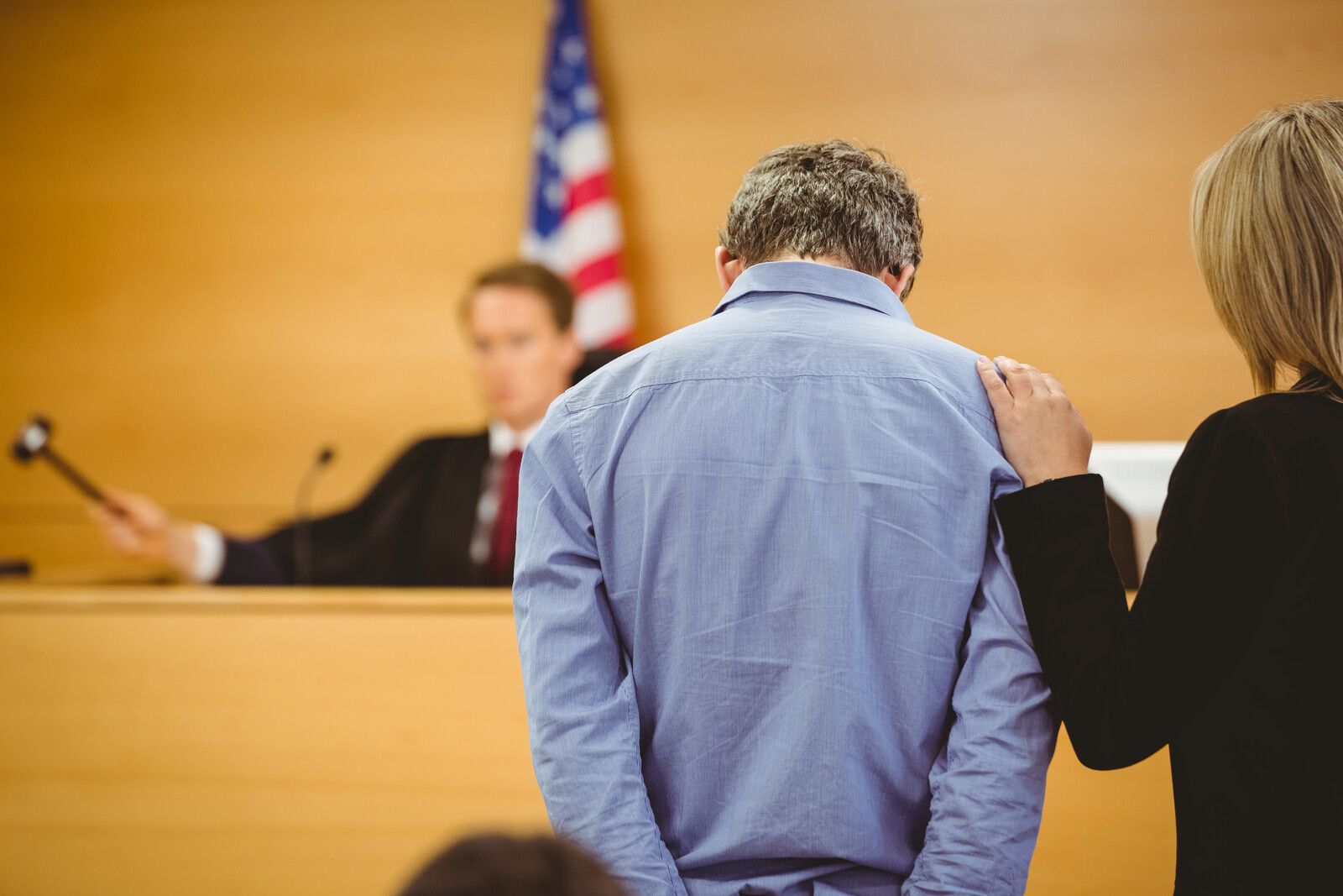 Man in the courtroom looking down in an article by Dr. Nancy Musarra on autism signs judges and law enforcement personnel should know.